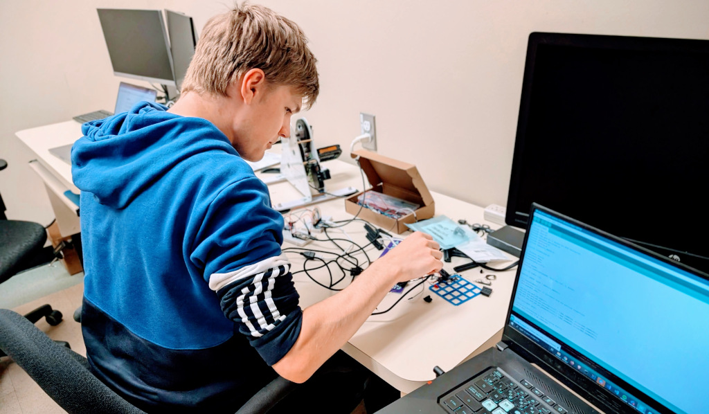 Une photographie de Thomas travaillant sur le prototype du veluqac